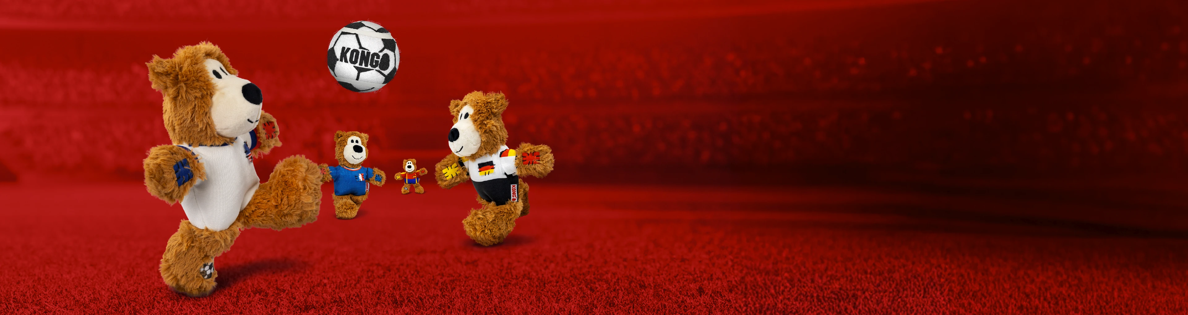 Bear stuffed animals playing soccer with different country jerseys on. The background is a red blurred out soccer field.