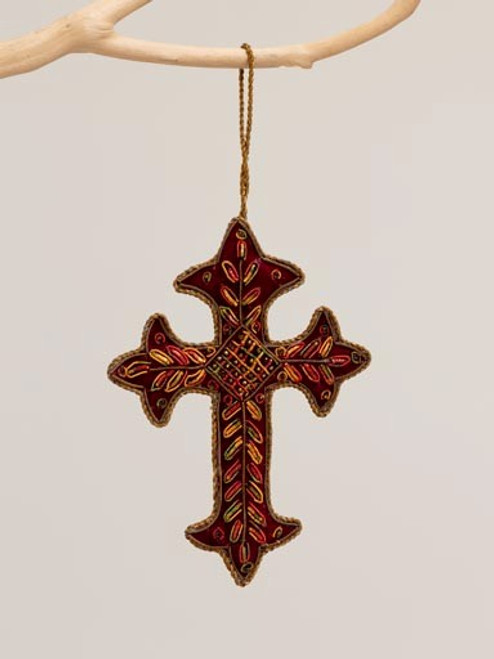 Image shows an embroidered burgundy cross ornament that is crafted with embroidery and lacework.