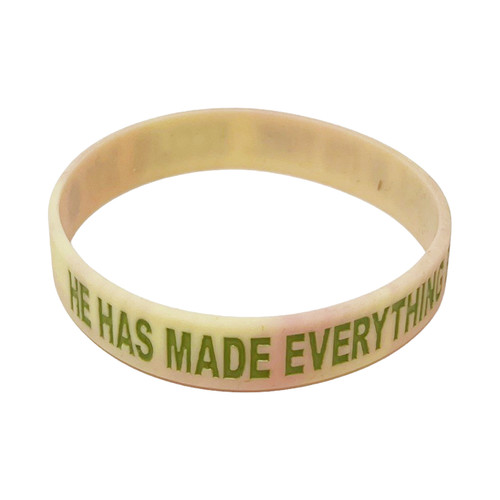 The image shows the front of a silicone bracelet with cherry blossoms and green letters.