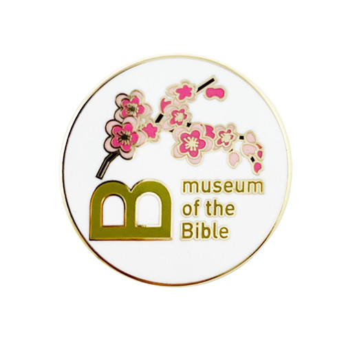The image shows the front of a Cherry Blossom Branch lapel pin from Museum of the Bible.