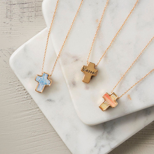 The image shows several cross necklaces on a flat surface. 