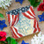 Image shows a curtain-type American flag tied back and shows the words God Shed His Grace On Thee. The small ornament on a table. 