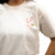 The image shows a close-up of the front of this cherry blossom branch t-shirt in cream.