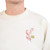 The image shows the front this cream-colored sweatshirt with a cherry blossom branch and the Museum of the Bible's "B."