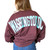 The image shows this Museum of the Bible Spirit Jersey long-sleeve shirt in cherry lacquer color. It has WASHINGTON DC printed across the shoulders.  