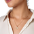 The image shows a woman wearing an olive leaf pendant necklace.