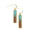 The image shows a close-up of Explorer Bar Earrings containing sand from the Dead Sea and turquoise stones.