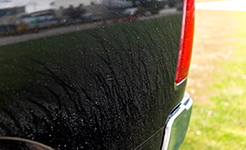 black fender of car with light dirt showing