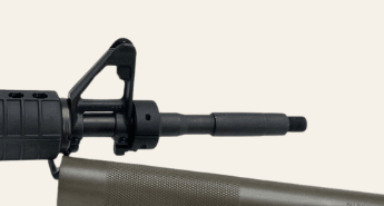 Close crop showing front sight base, three-piece collar, exposed barrel and muzzle end