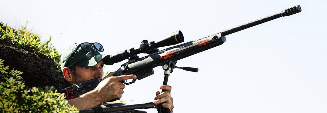 Shooter with rifle in an MDT CRBN stock takes aim off a tripod.