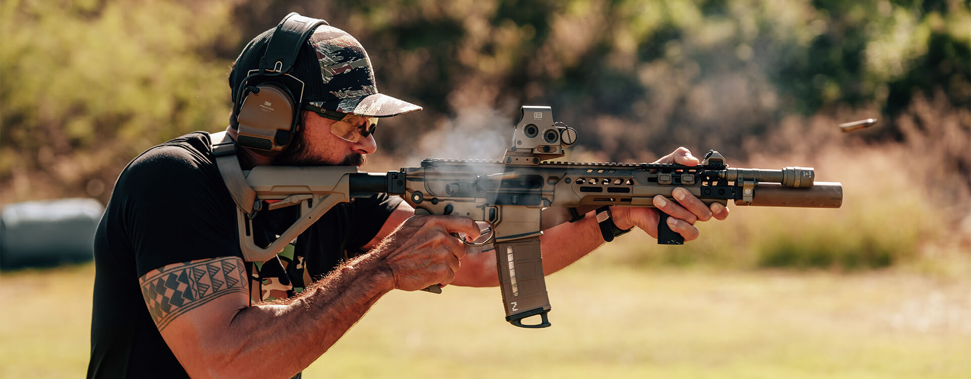 A man shooting a rifle equipped with the Magpul DT stock.