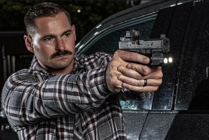 A man takes aim with a Glock equipped with a Surefire XR1 weaponlight.