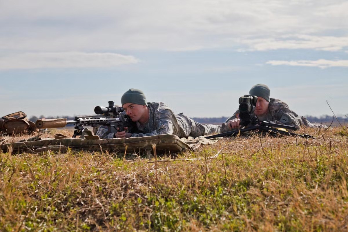 U.S. Army sniper behind an M2010 Enhanced Sniper Rifle with suppressor and bipod on a range