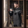 Tradesman wearing black Scruffs Fintry sweatshirt using a power drill on a construction site