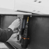 Black and white photograph of a drill being used vertically on metal panel