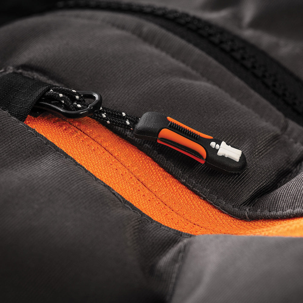 Close-up of Scruffs Trade Bodywarmer Black orange chest zip pull with rubberized logo tab