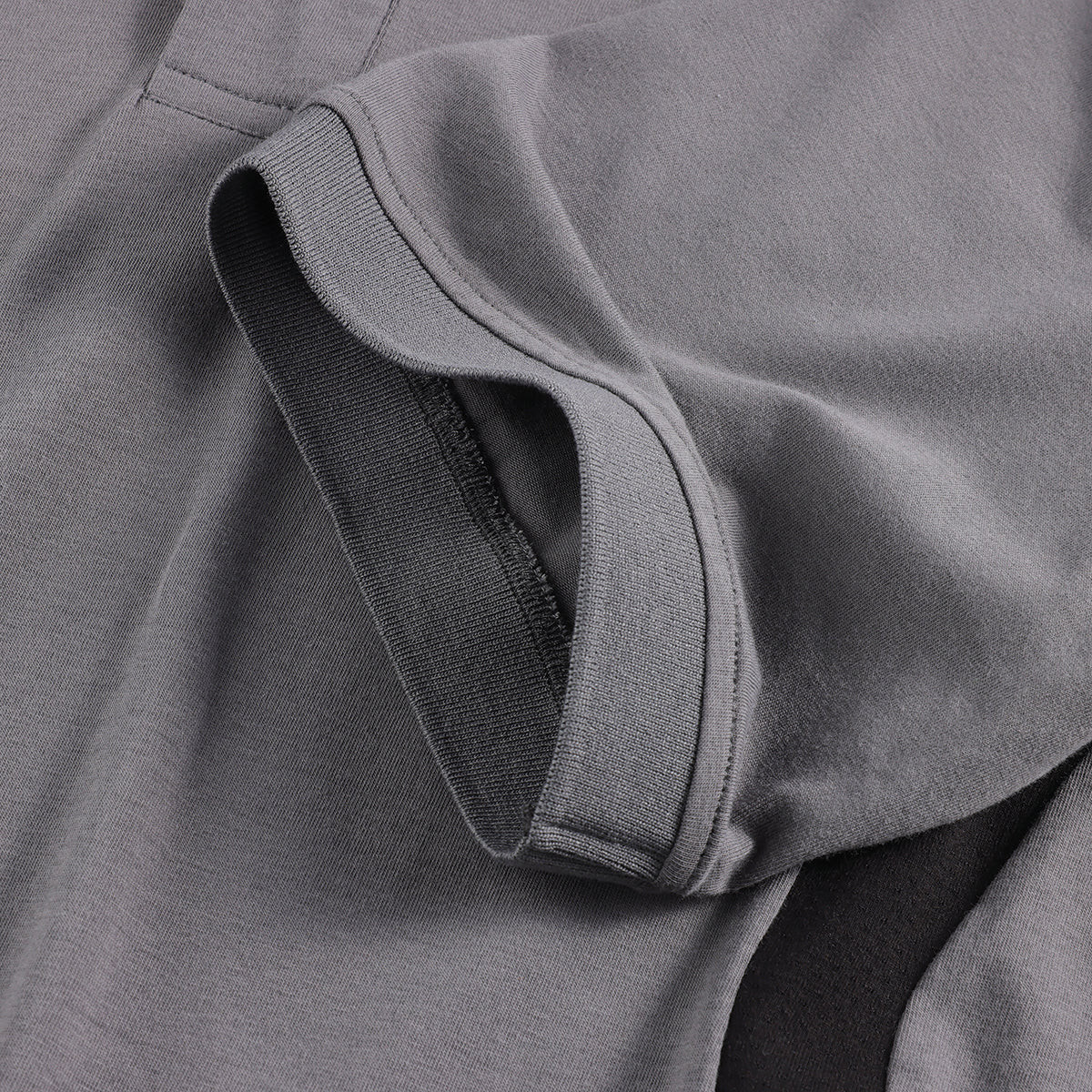 Scruffs Tech Polo Shirt Graphite sleeve cuff close-up showing ribbed trim and side panel seam
