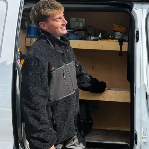 Scruffs Borley Sherpa Fleece worn by tradesperson beside work van showing black sherpa workwear fit