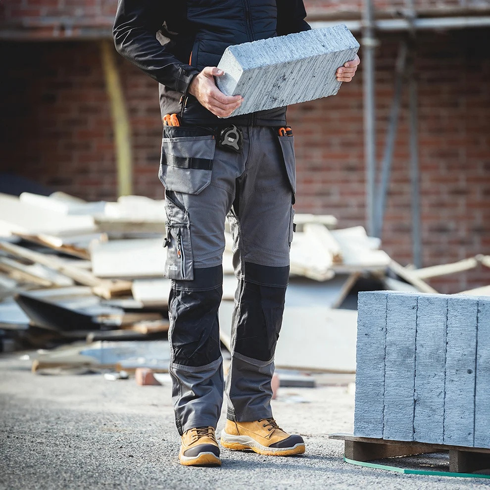 Scruffs Trade Holster Trousers worn by tradesperson carrying blocks on building site