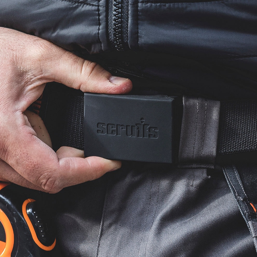Scruffs Trade Stretch Belt being worn with work trousers, showing the black branded buckle