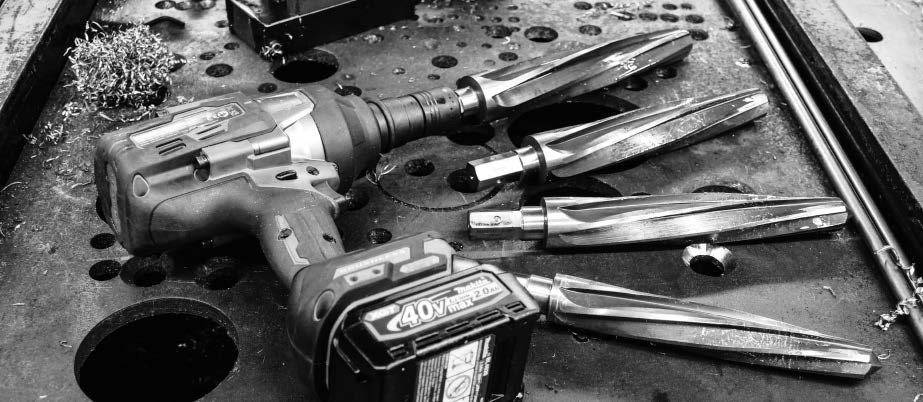 Impact wrench and several heavy-duty reamers on steel fabrication table