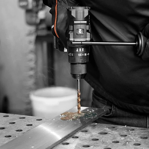 VersaDrive V18-120 drill boring into metal with cutting debris visible