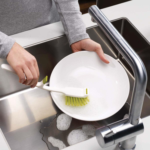 Green Joseph Joseph Edge Dish Brush in use