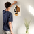 Enhanced Matte Paper Poster With Hanger 001. White Frame 12in x 18in (30.48cm x 45.72cm), Front View. Picture shows boho style drawing design with two brownish, irregular surface, geometric objects in the background and six leaf black branch in the foreground. Great Gift for Family, Friends, Coworkers, Self, and Others.