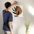 Enhanced Matte Paper Poster With Hanger 001. White Frame 18in x 18in (45.72cm x 45.72cm), Front View. Picture shows boho style drawing design with two brownish, irregular surface, geometric objects in the background and six leaf black branch in the foreground. Great Gift for Family, Friends, Coworkers, Self, and Others