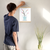 Enhanced Matte Paper Poster With Hanger 011. Oak Frame 12in x 16in (30.48cm x 40.64cm), Front View. Picture shows drawing of water in glass vase with branches sprouting colorful pink and yellow flower buds. Great Gift for Family, Friends, Coworkers, Self, and Others.