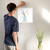 Enhanced Matte Paper Poster With Hanger 011. White Frame 16in x 16in (40.64cm x 40.64cm), Front View. Picture shows drawing of water in glass vase with branches sprouting colorful pink and yellow flower buds. Great Gift for Family, Friends, Coworkers, Self, and Others.