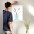 Enhanced Matte Paper Poster With Hanger 011. White Frame 18in x 24in (45.72cm x 60.96cm), Front View. Picture shows drawing of water in glass vase with branches sprouting colorful pink and yellow flower buds. Great Gift for Family, Friends, Coworkers, Self, and Others.