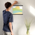 Enhanced Matte Paper Poster With Hanger 016. Black Frame, 14in x 14in (35.56cm x 35.56cm), Front View. Picture shows boho style drawing representing a sunset over hill-like shapes of green, blue, and orange. Great Gift for Family, Friends, Coworkers, Self, and Others.