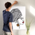Enhanced Matte Paper Poster With Hanger 018. White Frame 24in x 36in (60.96cm x 91.44cm), Front View. Picture shows boho design art drawing of lady of with hair wrapped, red lipstick, and large hanging earrings. Great Gift for Family, Friends, Coworkers, Self, and Others.