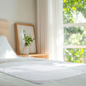 Heavy-Duty Reusable Incontinence Underpad on bed.