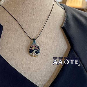Created from raw glass material, to-order, for you! Tiny Beaches are a wearable glass art painting of a wave and a sun, or a moon, depending on what one chooses to see. Made with love to be year-round reminders of vacation vibes. A unique gift for one who loves the beach!

Tiny Beaches are a handmade, flameworked glass art pendant necklace. Made by Tari Zarka at her Bucks County, Pennsylvania studio (AAOTE's home base).