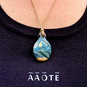 Tari Zarka’s Ocean Necklaces are truly little glass painting of the sea. They have a multi-layered effect, where the ocean and sand are in the foreground, and the sun and clouds are in the background. This design is a wearable miniature seascape created to keep the healing vibes of the sea near us all year long. Tari Zarka’s Ocean Necklaces are truly little glass painting of the sea. They have a multi-layered effect, where the ocean and sand are in the foreground, and the sun and clouds are in the background. This design is a wearable miniature seascape created to keep the healing vibes of the sea near us all year long.