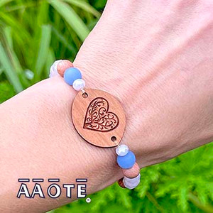 Our beautifully crafted wooden diffuser focals finished with shimmer and shine to bring colorful life to their already lovely functionality. Enjoy them by applying a few drops of essential oil to the engraved wood focal so as to enjoy aromatherapy all day long.
The wood focals are made in our shop in Pennsylvania, USA, and are sourced from sustainably grown American hardwood. The engraved image derives from AAOTE's Tari Zarka's artwork. Variations in the wood's grain and color are natural distinctions making each piece unique.