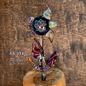 Flameworked glass art sculpture by AAOTE's founder, Tari Zarka. Totally one-of-a-kind, investment-quality glass art on a wooden base. 

The Sea Turtle features a flower implosion design with sculptural seaweed. It's a 3-piece set including the wood base. The overall size is approximately 7.75"H x 3.25"W x 3.25"D.

There is only one available. The piece you see is the piece you get. It will arrive dissassebled. The glass pieces slide out of the base, and get wrapped separate from the base for safe shipment. Assembly is as easy as sliding the glass rods into the wooden base. 

The wooden base is actually crafted from fallen timber from AAOTE's property. 

This sculpture will ship USPS Priority with insurance and is not eligible for free shipping offers.