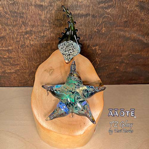 Flameworked glass art sculpture by AAOTE's founder, Tari Zarka. Totally one-of-a-kind, investment-quality glass art on a wooden base.
This Sea Star with dichroic glass in whirling skies design is gorgeous. It's a 3-piece set including the wood base. The overall size is approximately 7.5"H x 4.5"W x 4.25"D.
There is only one available. The piece you see is the piece you get. It will arrive dissassebled. The glass pieces sit on the base, and gets wrapped separate from the base for safe shipment. Assembly is as easy as placing the glass onto the wooden base.
The wooden base is actually crafted from fallen timber from AAOTE's property.
This sculpture will ship USPS Priority with insurance and is not eligible for free shipping offers. Flameworked glass art sculpture by AAOTE's founder, Tari Zarka. Totally one-of-a-kind, investment-quality glass art on a wooden base.
This Sea Star with dichroic glass in whirling skies design is gorgeous. It's a 3-piece set including the wood base. The overall size is approximately 7.5"H x 4.5"W x 4.25"D.
There is only one available. The piece you see is the piece you get. It will arrive dissassebled. The glass pieces sit on the base, and gets wrapped separate from the base for safe shipment. Assembly is as easy as placing the glass onto the wooden base.
The wooden base is actually crafted from fallen timber from AAOTE's property.
This sculpture will ship USPS Priority with insurance and is not eligible for free shipping offers.