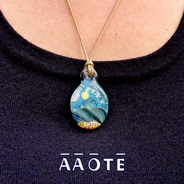 Tari Zarka’s Ocean Necklaces are truly little glass painting of the sea. They have a multi-layered effect, where the ocean and sand are in the foreground, and the sun and clouds are in the background. This design is a wearable miniature seascape created to keep the healing vibes of the sea near us all year long.