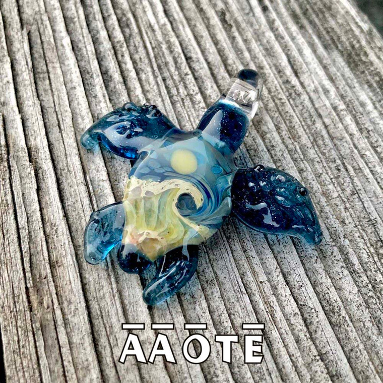 These whimsical turtle shaped necklaces are mini sculptures and paintings all in one; quite the statement piece! They feature Tari Zarka’s popular Beaches design on the body of a sea turtle sculptural glass pendant.