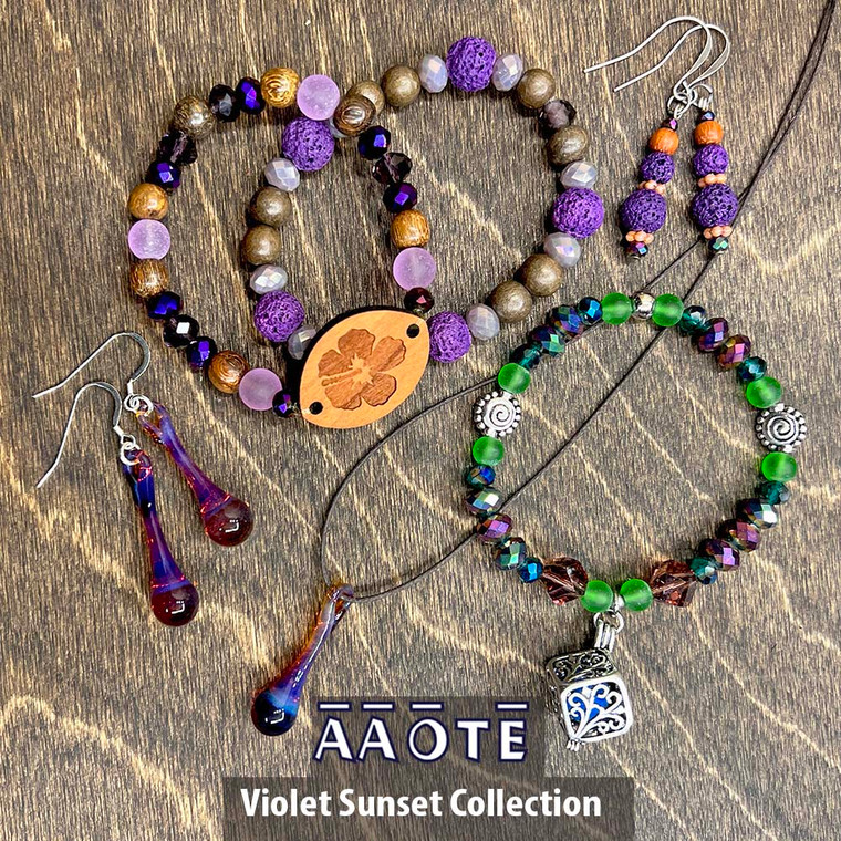 Our Violet Sunset Collection features a luscious purple palette.

Comprised of TZ Glass Drop of Positivity Necklace and Earrings in Sunset, Wood Diffuser Beaded Stretch Aromatherapy Bracelet in Hibiscus, Lava Diffuser Aromatherapy Bracelet in Purple, Lava Diffuser Aromatherapy Earrings in Violets, and a Cage Diffuser Aromatherapy Bracelet in Mardi Gras. Choose just one or go for a few. They look great together!