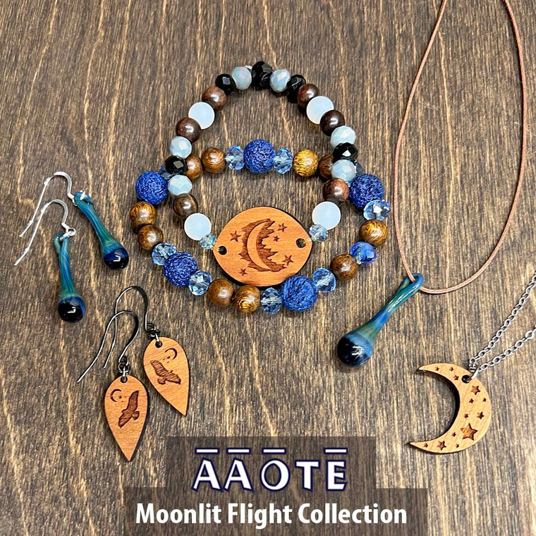 Our Moonlit Flight Collection features midnight blues to medium grey-blues. 

It includes our Wood Diffuser Aromatherapy Earrings Hawk w/ Moon, TZ Glass Drops of Positivity Earrings in Denim, Lava Diffuser Beaded Stretch Bracelet in Sapphire, Wood Diffuser Beaded Stretch Bracelet in Moon, Drop of Positivity Glass Necklace in Denim, and a Wood Diffuser Aromatherapy Necklace in Crescent Moon. Enjoy just one or a few pieces, they look great together!