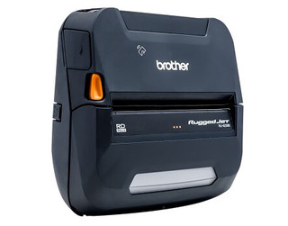 Close-up of a Brother portable label printer printing a barcode label wirelessly next to a smartphone and tablet