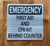 emergency-first-aid-cpr-kit-behing-counter-aluminum-sign-peel-and-stick.jpg