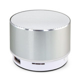 A silver Bluetooth speaker with a textured top and a white base, featuring a subtle logo.