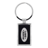 A silver keychain featuring a rectangular design with a black background and a logo.