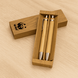 A bamboo pen set in a wooden box featuring two stylus pens with silver accents and a logo.