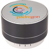A black aluminium Bluetooth speaker with a circular design and a colourful logo on top.